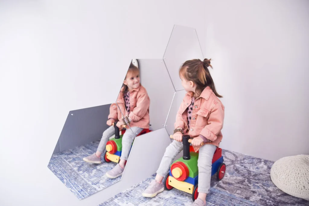 Kids are playing indoor while using mirror 