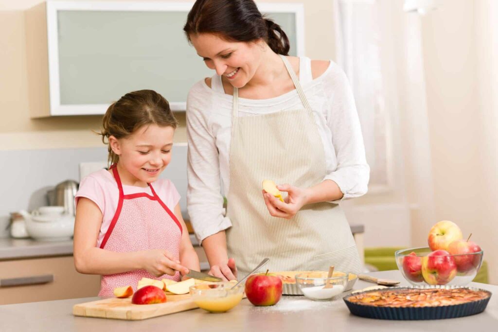 Mother teaching a preschooler how to cook or bake