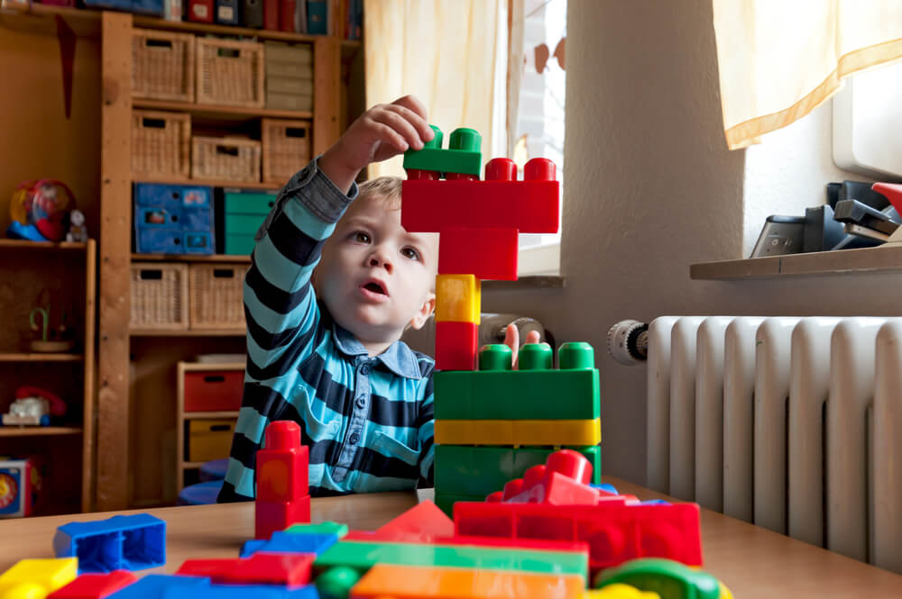Small Autistic boy building toys
